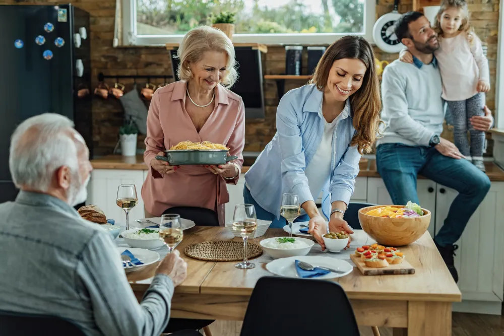 Zwei Frauen decken den Esstisch für ein Familienessen